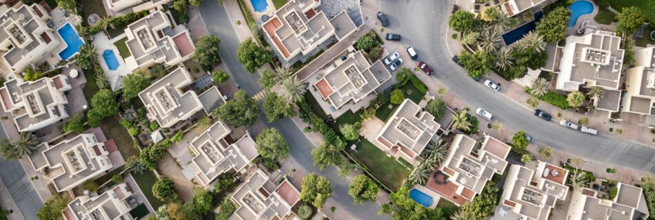 Explore a stunning aerial view of a residential area in Dubai with lush greenery and swimming pools.